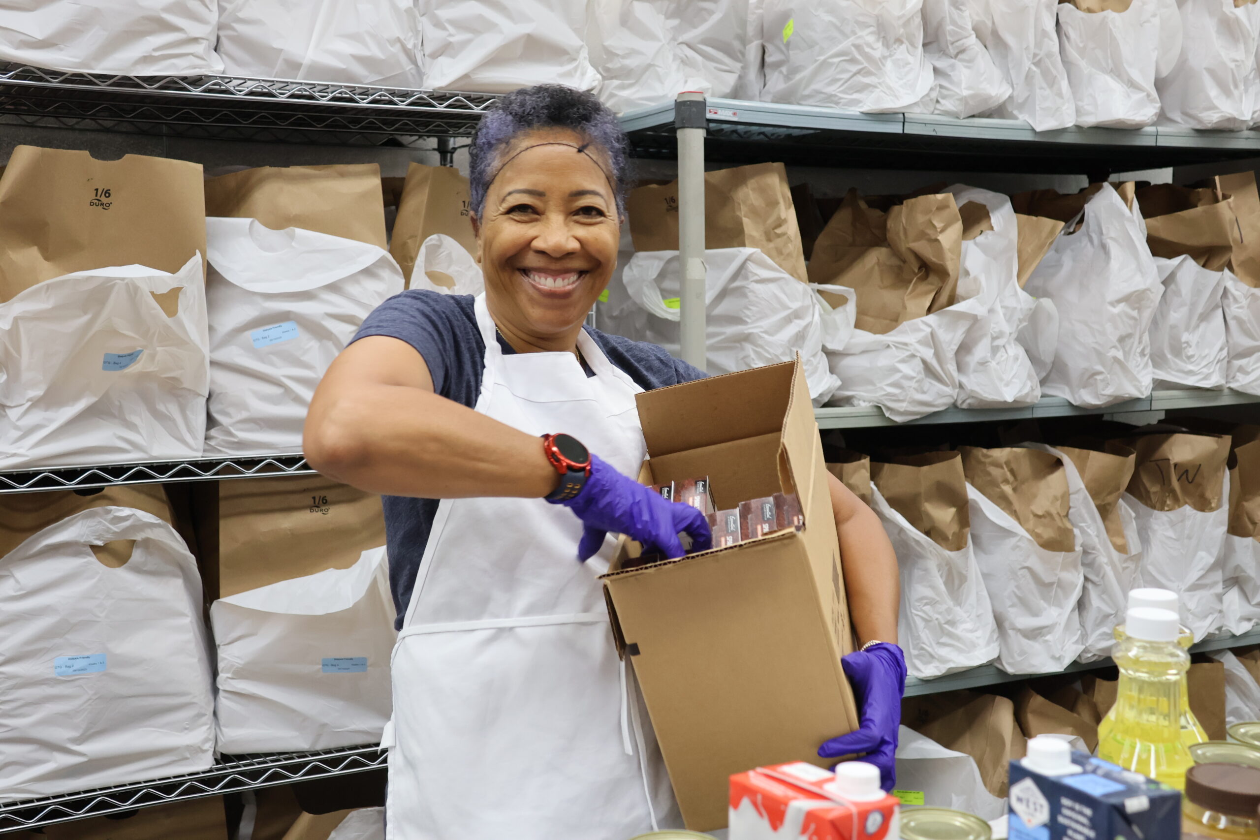 A volunteer packs medically tailored groceries